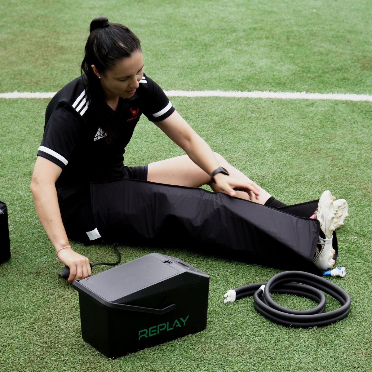 Athlete using Replay Pro ice compression full leg wrap for soccer recovery on field