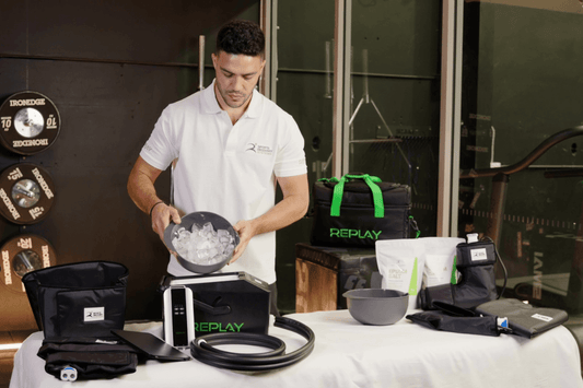 Person setting up Replay Pro ice compression system with ice and wraps on a table, showing how to prepare and use the unit for recovery.