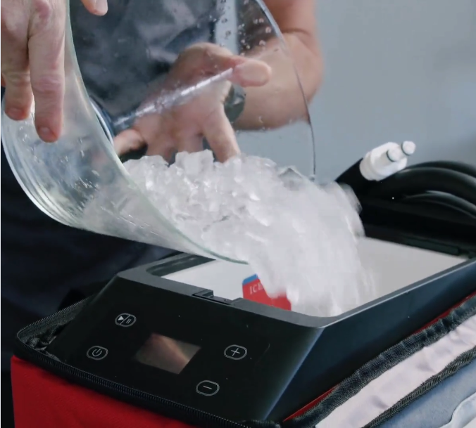 Person pouring ice into a Replay Pro ice compression unit, showing how cold therapy is prepared for muscle recovery and swelling relief.