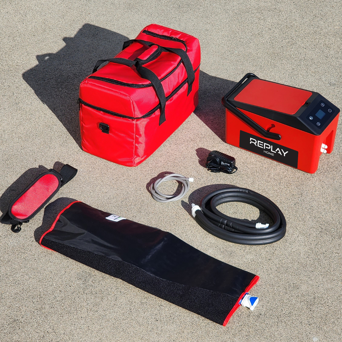 Replay Home ice compression unit complete set with carry bag, power cable, wrap and hose shown outdoors