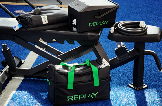 Replay Pro ice compression therapy unit without battery pack shown in a gym hero setup with carry bag and hose on bench